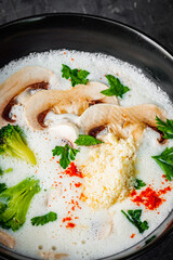 creamy mushroom soup with champignons on a black background