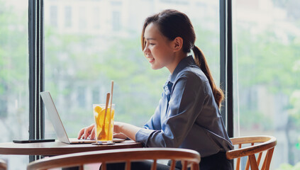 Image of young Asian businesswoman working at coffee shop
