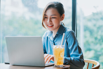 Image of young Asian businesswoman working at coffee shop