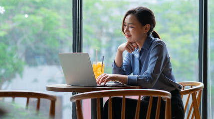 Image of young Asian businesswoman working at coffee shop