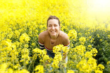 Portrait of a smiling woman in a yellow field during the summer