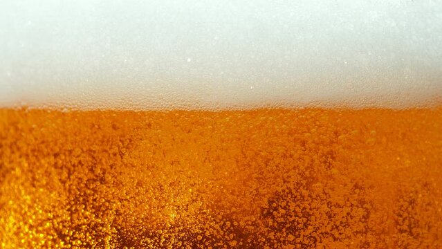 Super slow motion of macro shot of beer drink bubbling, close-up. Filmed on high speed cinema camera, 1000 fps.