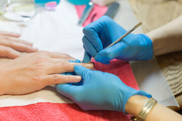 Self emplyed woman making manicure on side. Close up focus on hands.