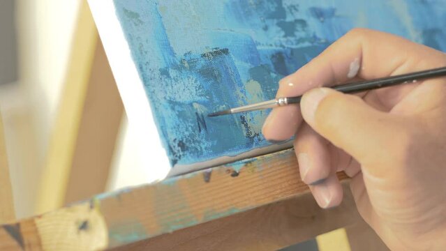 Artist signs his name on completed painting. Realtime