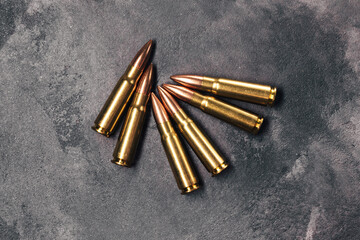 Bullets on gray background. Cartridges 7.62 caliber for Kalashnikov assault rifle. Top view, flat lay