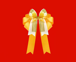 Golden fabric bow isolated on red background