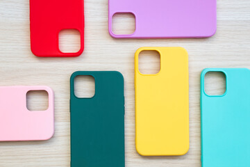 Cases set for smartphone on wooden background. Silicone protection for mobile phone. Colorful...