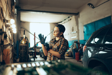 Destroying gender stereotypes. Young woman auto mechanic working at auto service station using...