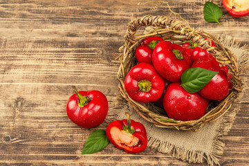 Ripe red round peppers in a handmade wicker basket
