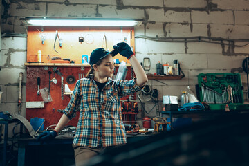 Female auto mechanic, beautiful young girl in working process at auto service station, indoors....