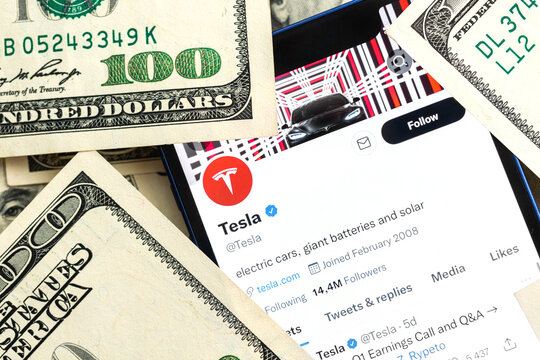 Tesla car company stock market background. Tesla logo on Twitter and dollar money close-up view photo