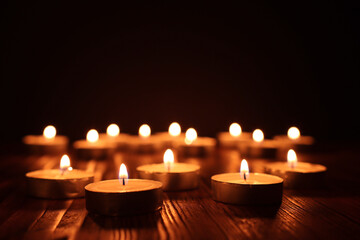 Burning candle over black background