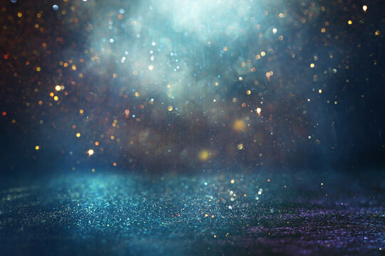background of abstract glitter lights. gold and blue. de focused