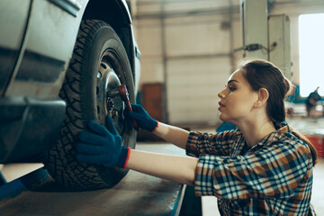 Female auto mechanic, beautiful young girl in working process at auto service station, indoors....