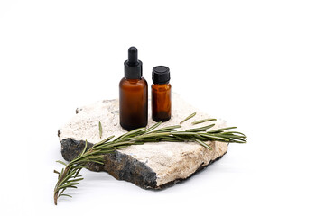 Rosemary Essential Oil Bottles on stone podium, against white background.