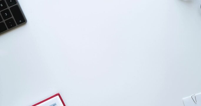 Flatlay with office items and place for text. Layout on a white background. Glasses, keyboard, pen, paper clips, diary, work papers. 4K looped stop motion animation