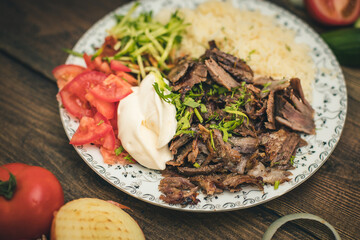 doner or shawarma called pilav ustu on rice, with yogurt , tomatoes and herbs