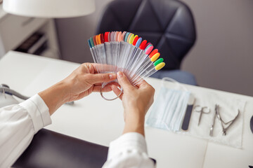 Woman client with palette of nail varnishes in beauty shop