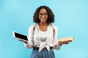Online education vs offline studies. Black female student with backpack holding textbook and...