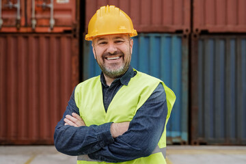 Happy senior man smiling at camera working at industrial shipping freight terminal port - Focus on face