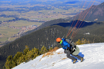 Paraglider on Tegelberg mountain. Bavaria, Germany, Europe.