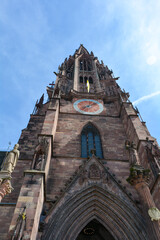 Fototapeta na wymiar Tower of the Freiburg Minster with clock in the city of Freiburg
