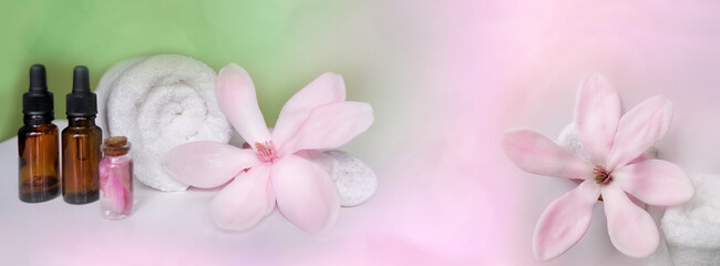 beautiful pink magnolia flower, smooth white stones, white towel rolled up, concept of wellness spa...