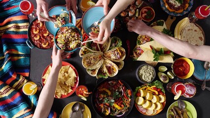 An authentic Mexican family celebrates Cinco de mayo together at a festive table. Mexican food - obrazy, fototapety, plakaty