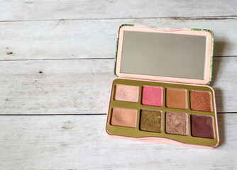 Nude eye shadow palette on wooden background 
