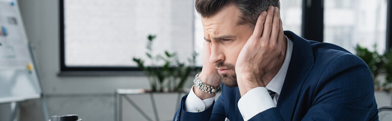 frustrated businessman frowning and touching head in office, banner.