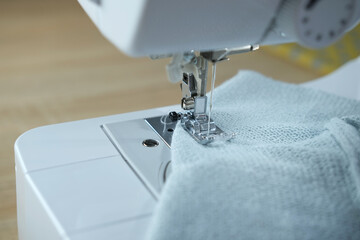 close-up of white sewing electric computer machine, stitches appear step by step on the fabric, concept of tailoring, women's hobby, modern needlework, seamstress profession