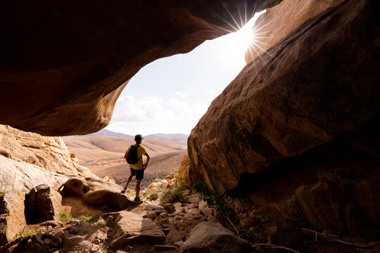 Man enjoying the view standing inside the sandstone canyons, Barranco de las Penitas, Fuerteventura, Canary Islands