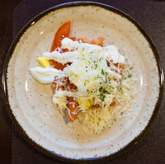 plate with a mix of tomatoes, cheese, eggs with french sauce. . top view