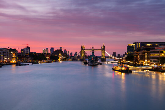 Tower Bridge, HMS Belfast, River Thames and Canary Wharf skyline at sunrise, London