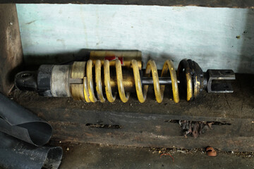 Automatic motorcycle rear shock breaker. Dirty mono-shock absorbers and yellow coil springs. Motorcycle rear suspension for a comfortable ride.