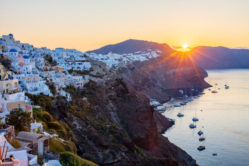 Sunrise over coast of Oia and typical white buildings, Santorini, Cyclades, Greek Islands