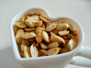 A bowl of peanuts. Nuts in a mug.