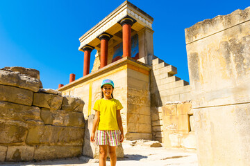 A little girl stops to take a photo of artwork on the walls of the Minoan palace at Knossos. Crete, Greece