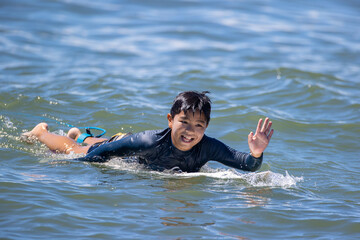 湘南の海でサーフィンをする少年
