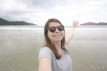 Happy Young Woman Taking a Selfie Portrait. Smilling Woman Tralling to the Beach.
