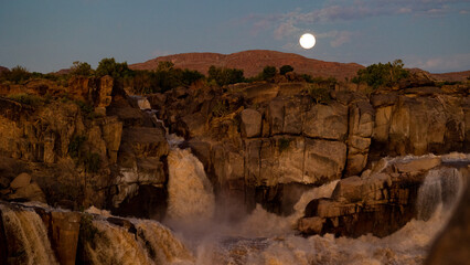 moon rising over a waterfall