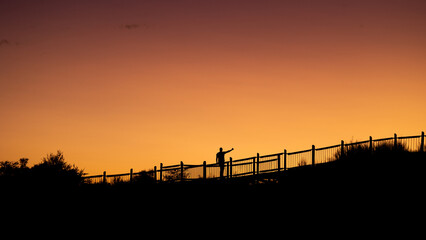 a distant Human Silhouette at sunset