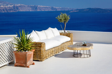 A sun terrace with sofa in Thira, Santorini island, Greece. Beautiful rest place over the caldera