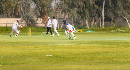 young boys playing cricket in the local city playground 