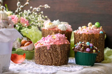 Large and small Easter cakes with pink icing and chocolate icing, decorated with multi-colored dragees
