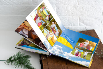 Family photos archive saved in brightly designed photo book; bright summer memories placed in the photobook. family with flag of ukraine