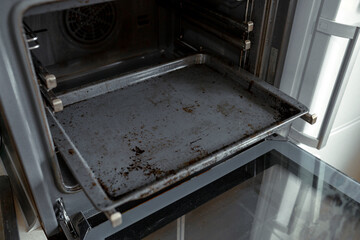 Dirty oven after cooking a greasy dish in the kitchen
