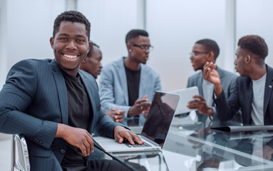 young businessman uses laptop sitting at office Desk.