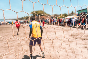Selective focus photo of an unrecognizable goalkeeper protecting the goal during a soccer game on a...