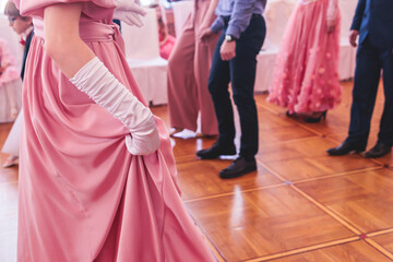 Couples dance on the historical costumed ball in historical dresses, classical ballroom dancers dancing, waltz, quadrille and polonaise in palace interiors on a wooden floor, opera gloves close-up